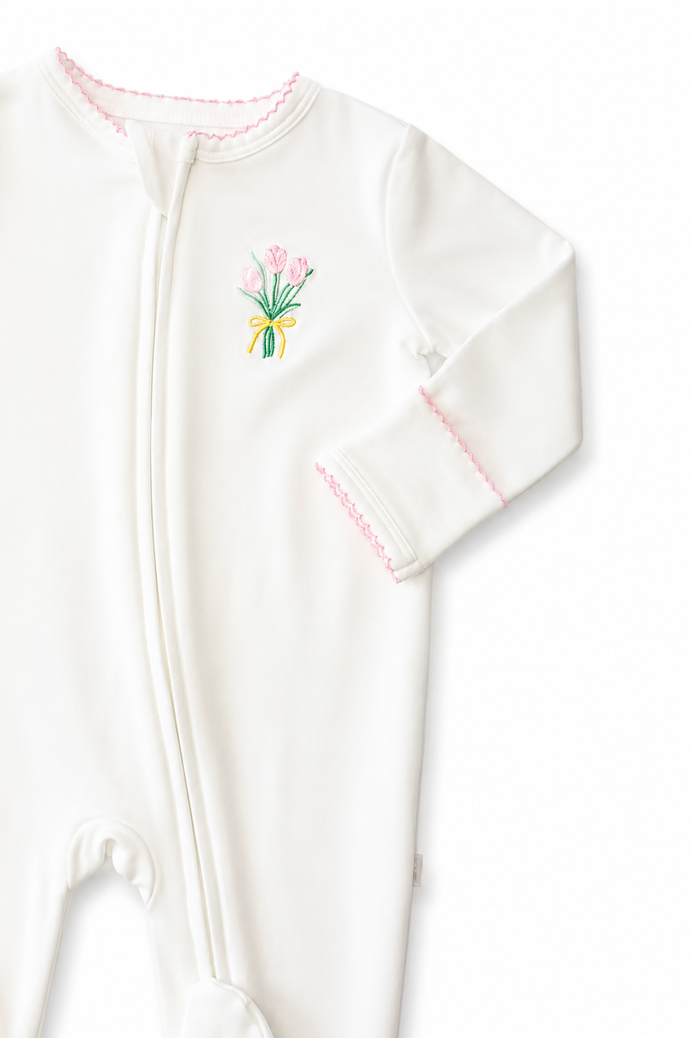 White baby footie with floral embroidery on a white background