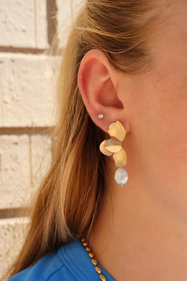 Sarah gold flower and pearl statement earring worn on the ear for an elevated feminine look