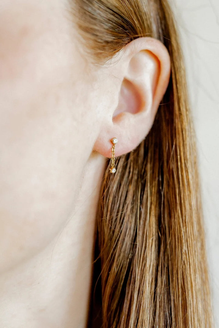Holland gold crystal chain-drop screwback stud earring styled on the ear