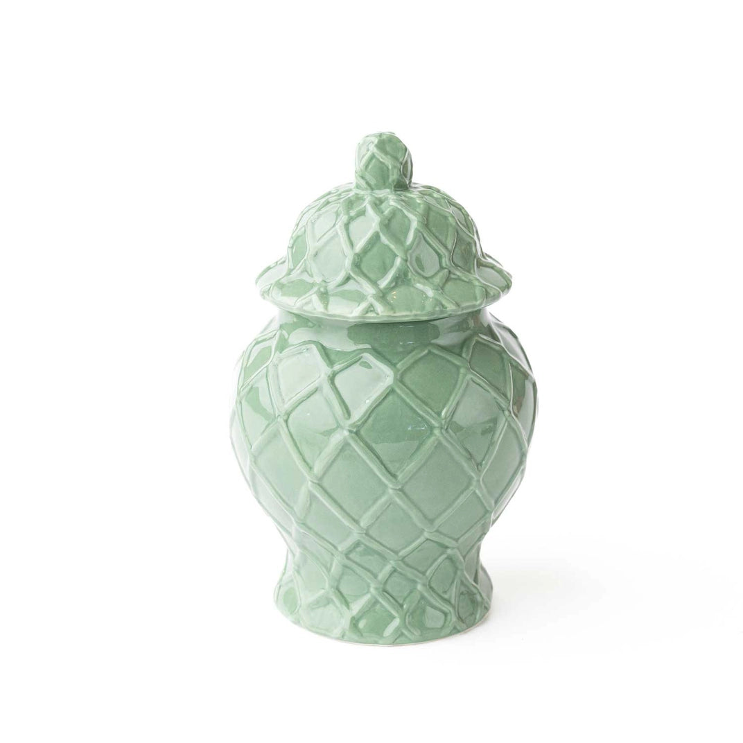 Green ceramic jar with a textured design on a white background