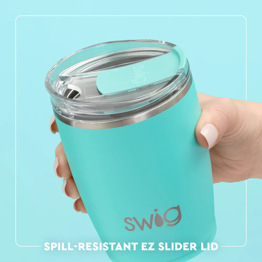 Turquoise tumbler with spill-resistant EZ Slider lid held by a hand on a light blue background