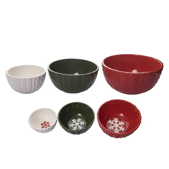 ceramic bowls in red, green, and white with snowflake designs on a white background.
