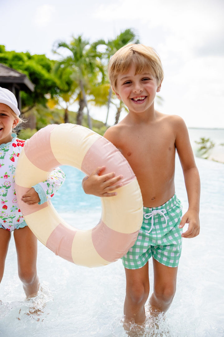 Two children playing in water with a colorful inflatable ring.