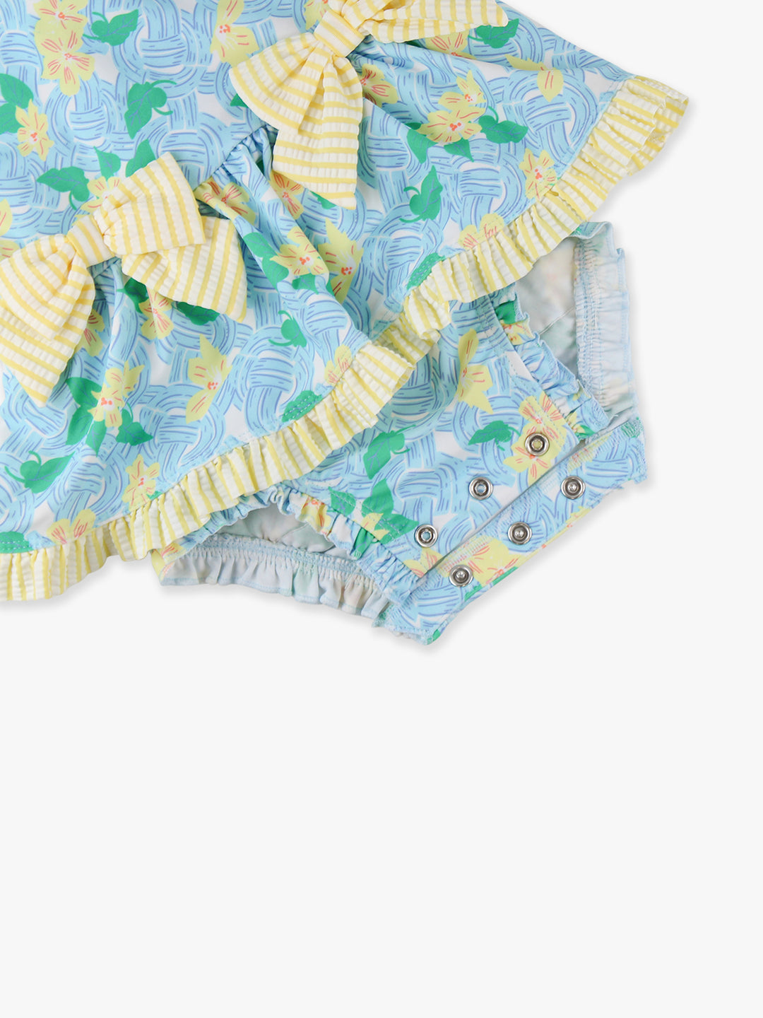 Two baby rompers with pineapple pattern and ruffled edges on a white background