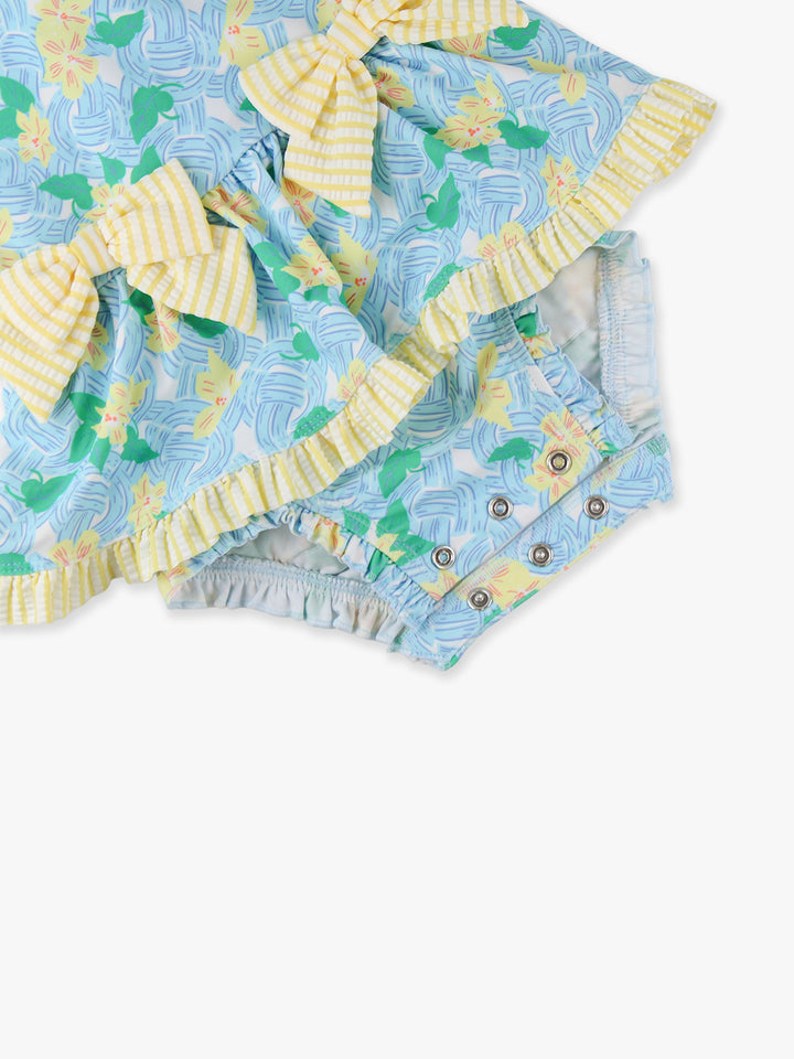 Two baby rompers with pineapple pattern and ruffled edges on a white background