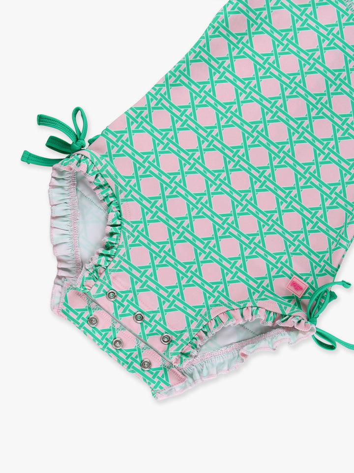 Green and pink patterned baby romper with ruffled details on a white background