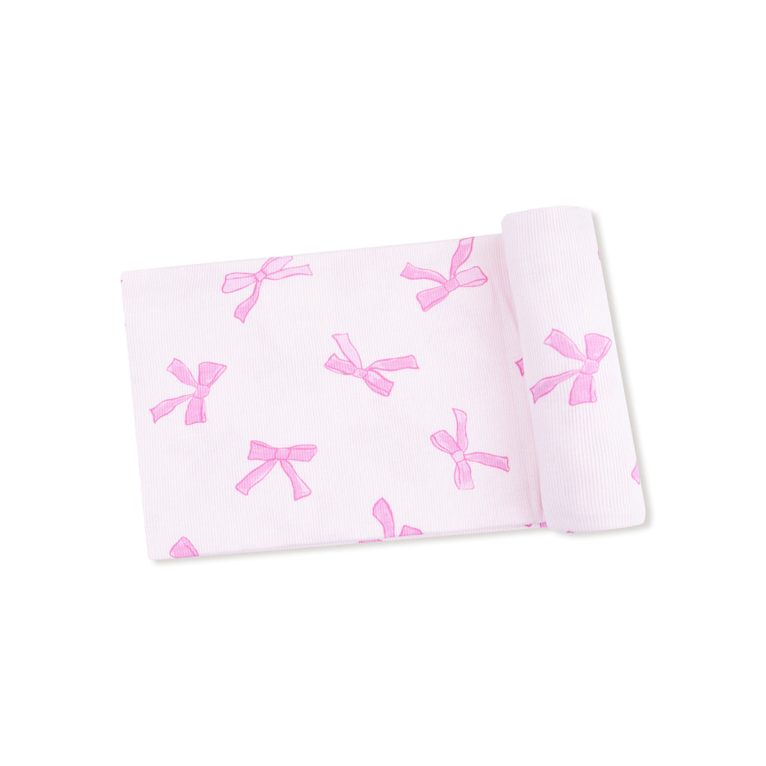 Pink bow-patterned fabric on a white background
