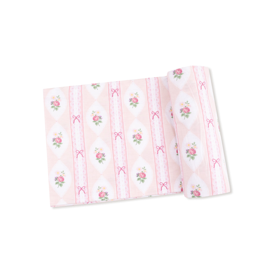 Pink fabric with floral and bow patterns on a white background