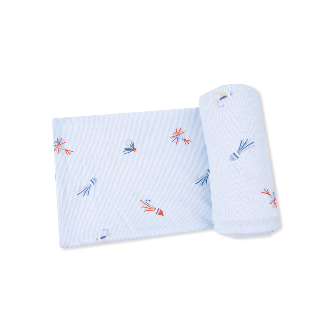 Light blue fabric with colorful embroidered designs on a white background