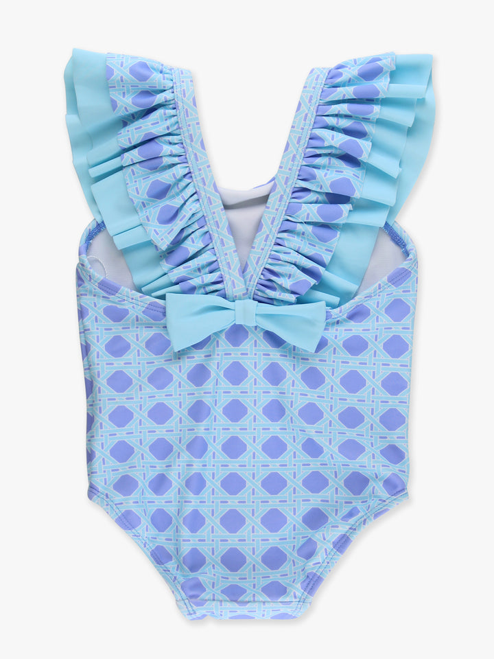 Blue polka dot swimsuit with ruffled details on a white background