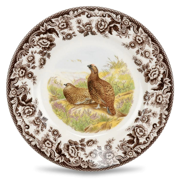 A Spode woodland salad plate with a black and white design featuring a dog in a field, surrounded by floral patterns.