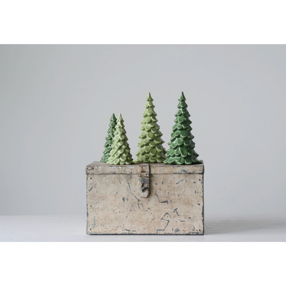 Three green Christmas trees in a rustic wooden box on a light gray background