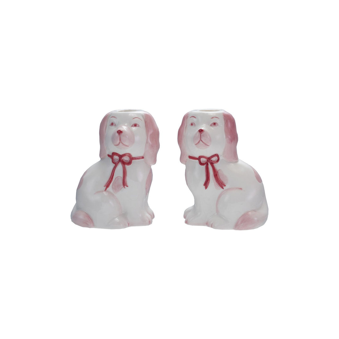 Two ceramic dog figurines with red bows on a white background