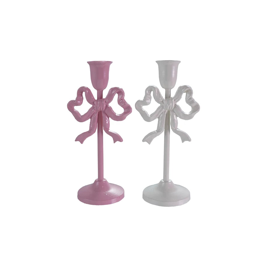 Two bow-shaped candle holders, one pink and one white, on a white background.