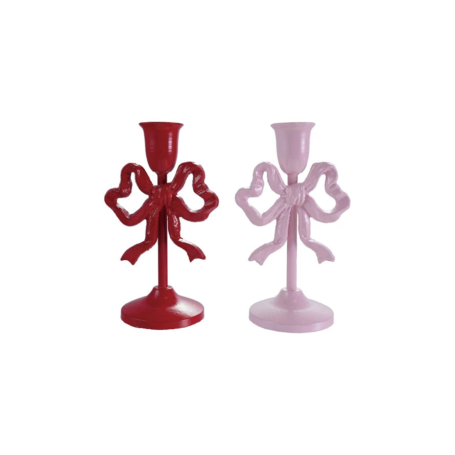 Red and pink bow-shaped candle holders on a white background
