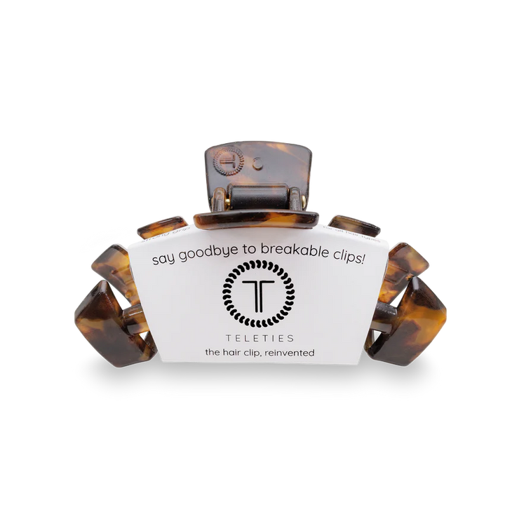 A Teleties hair clip in a tortoiseshell pattern, shown with its white branded cardboard packaging on a clean white background.