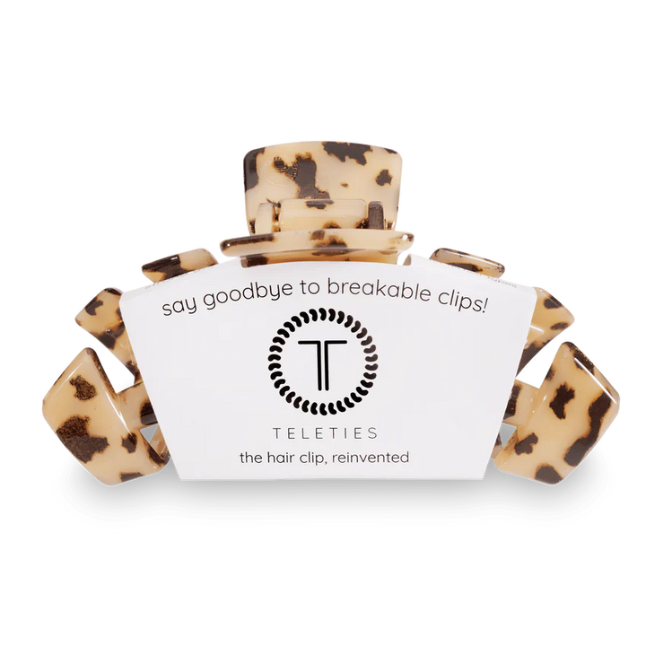 A Teleties hair claw clip in a tortoiseshell pattern, shown with its white branded paper sleeve on a plain white background.