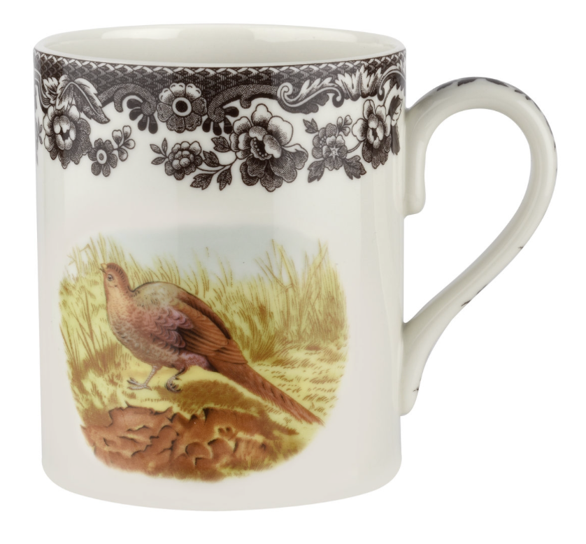 A white ceramic mug with a pheasant bird illustration and black floral patterns on the handle and rim.