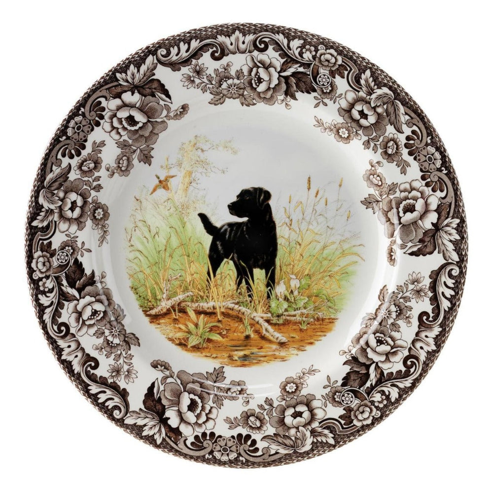 A Spode woodland salad plate with a black and white design featuring a dog in a field, surrounded by floral patterns.