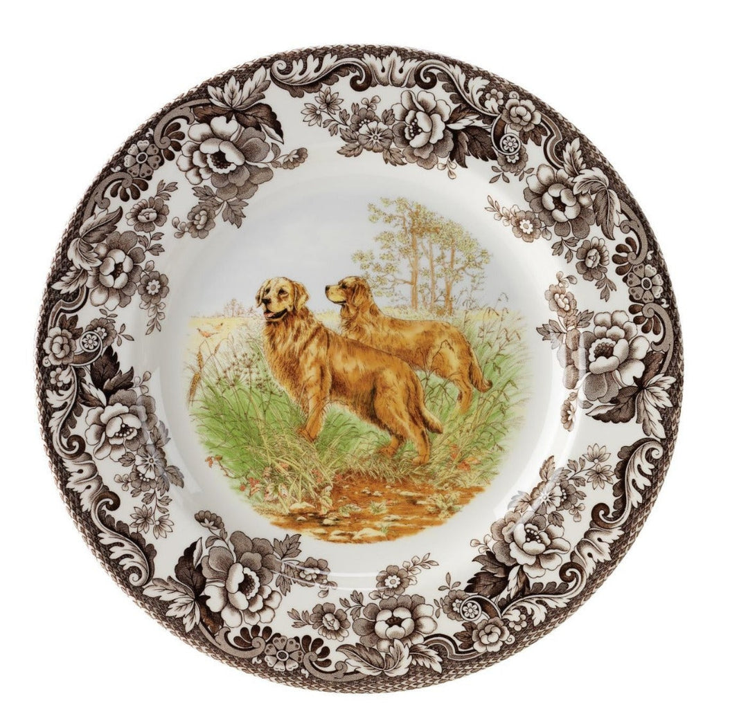 A Spode Woodland Salad Plate featuring an illustration of a black lab dog in a field with floral and scroll designs around the border.