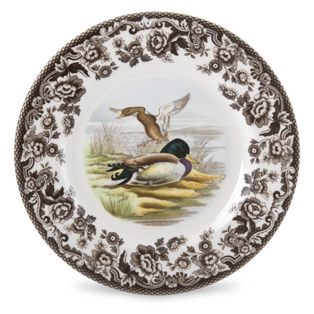 A round ceramic salad plate with a brown and green bird design in the center, surrounded by a floral pattern, on a white background.