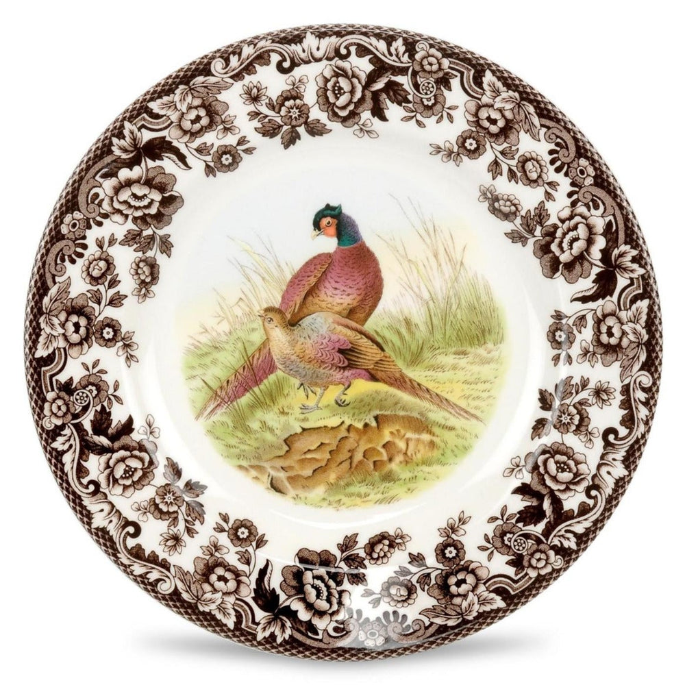 A round ceramic salad plate with a brown and green bird design in the center, surrounded by a floral pattern, on a white background.