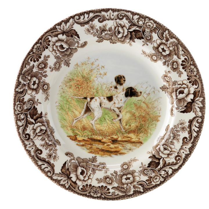 A Spode woodland salad plate with a black and white design featuring a dog in a field, surrounded by floral patterns.