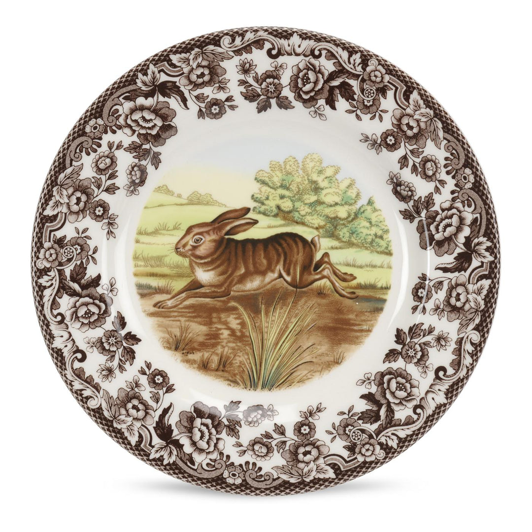 A Spode Woodland Salad Plate featuring an illustration of a black lab dog in a field with floral and scroll designs around the border.