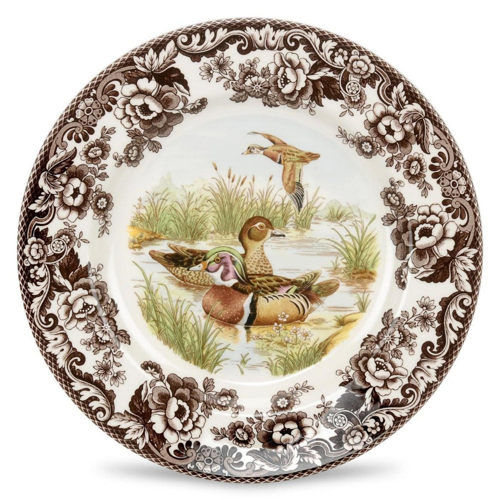 A Spode woodland salad plate with a black and white design featuring a dog in a field, surrounded by floral patterns.